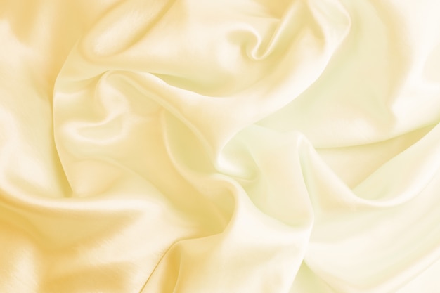 Satén lujoso de la textura de seda poner crema hermosa para el fondo abstracto. enfoque suave