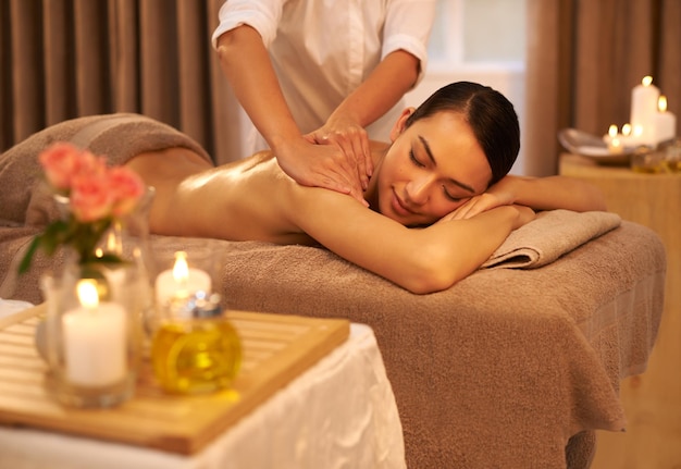 Foto satisfazendo seus sentidos no spa uma bela jovem desfrutando de uma massagem no spa