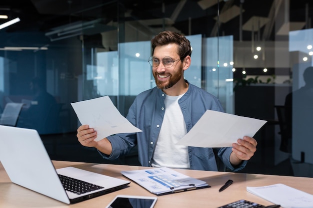 Satisfecho con el resultado, el empresario financiero tiene en sus manos y examina los contratos y