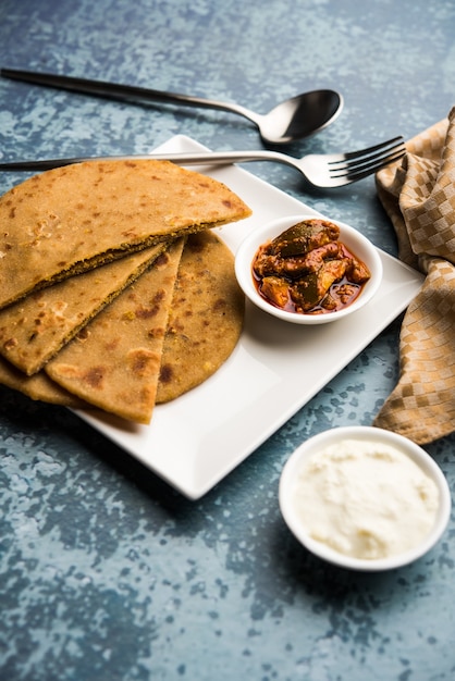 Sattu Ka Paratha Rellena Channa Dal Harina Paratha servida con pepinillo de mango y cuajada o dahi