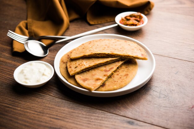 Sattu Ka Paratha Rellena Channa Dal Harina Paratha servida con pepinillo de mango y cuajada o dahi