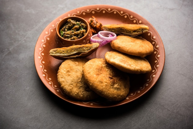 Sattu Litti chokha frito servido con Baingan Bharta, cebolla y pepinillos, receta popular de Bihar, India