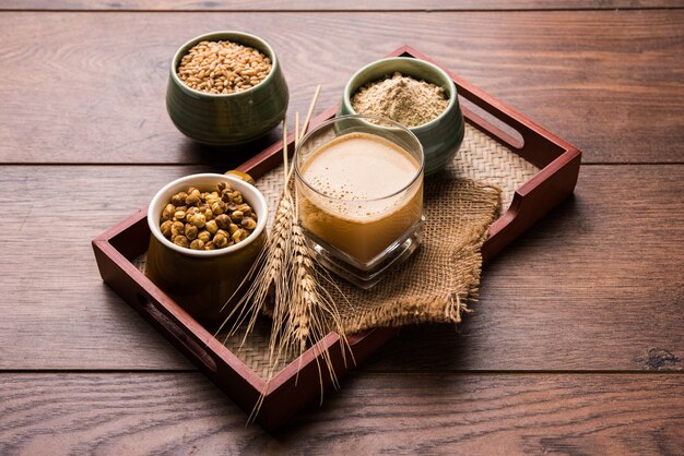 Sattu sharbat é uma bebida doce refrescante feita no verão com farinha de grão de bico preto torrado, cevada, suger, sal e água. servido em um copo. foco seletivo