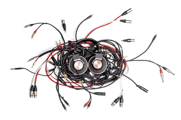 Satz Audiokabel verschiedener Typen und professioneller Kopfhörer auf weißem Hintergrund.