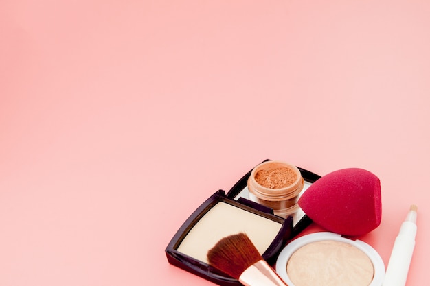 Satz bunte Kosmetik auf rosa Holztischhintergrund, Basis für Make-up in Form eines Kissens. Speicherplatz kopieren