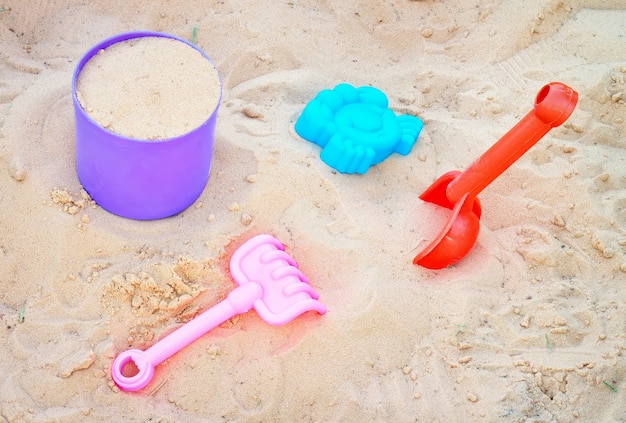 Satz bunte Plastikspielzeuge auf einem Sand. Sandkasten