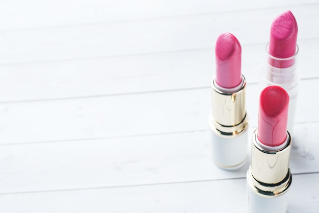 Satz farbige rosa Lippenstifte auf weißem Hintergrund. Kosmetik für Frauen. Selektiver Fokus Platz kopieren.