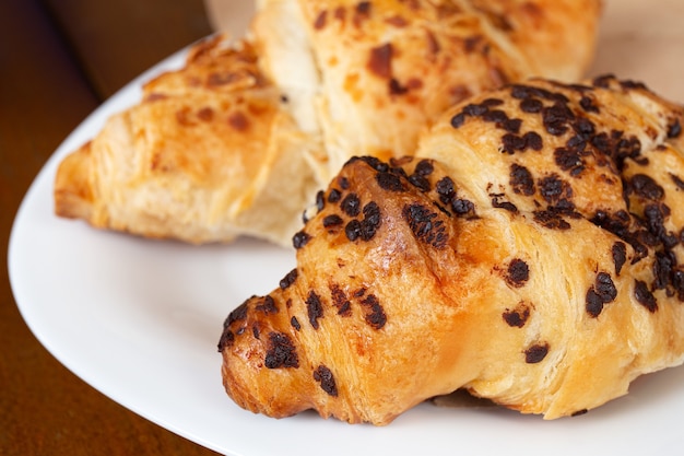 Satz frisch gebackene Croissants auf Holztisch. Französisches Croissant.