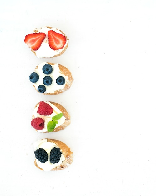 Satz kleine süße sandwiche mit frischkäse und frischen waldbeeren