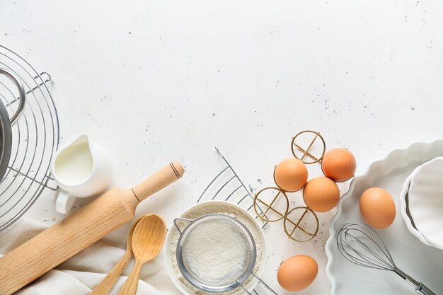 Satz Küchenutensilien und Zutaten für die Zubereitung der Bäckerei auf hellem Hintergrund