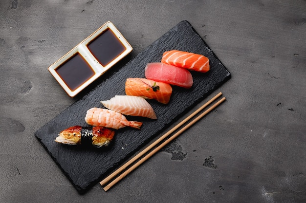 Satz Nigiri-Sushi serviert auf Teller auf grauem Tisch