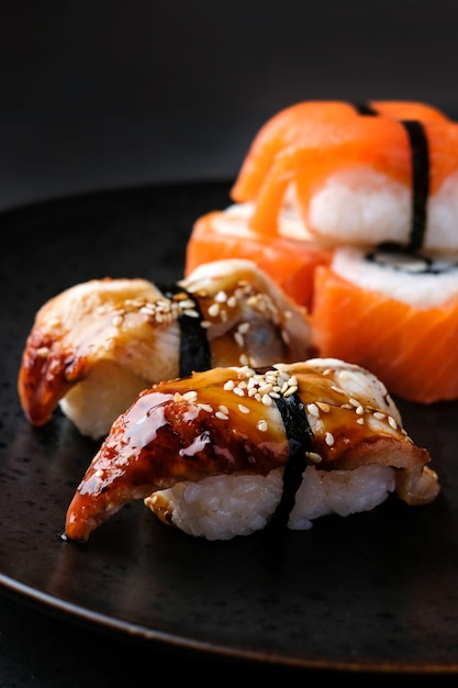 Satz traditionelles japanisches Nahrungsmittelsushi mit rotem Fisch am schwarzen Tisch