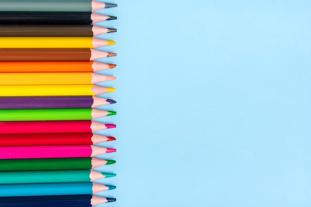 Foto satz von buntstiften isoliert auf blauem hintergrund ansicht von oben flach gelegt bildung handwerkskonzept