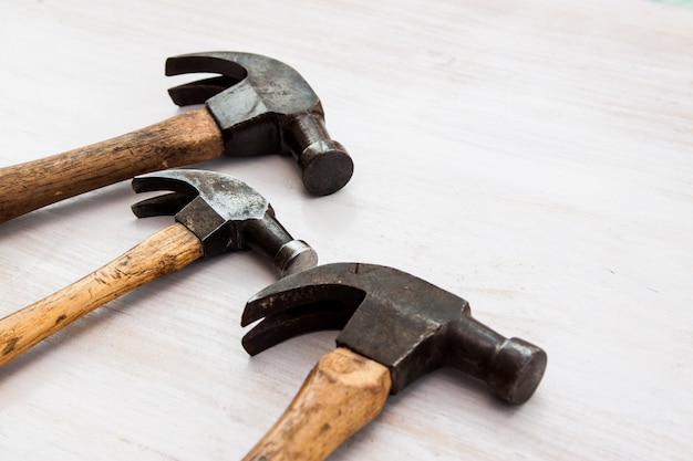 Satz von drei alten alten Hammerwerkzeug Hammerkopf auf dem Holzfußbodenhintergrund