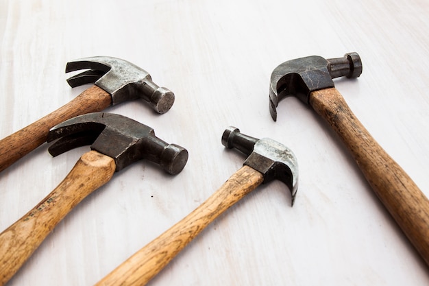 Satz von drei alten alten Hammerwerkzeug Hammerkopf auf dem Holzfußbodenhintergrund