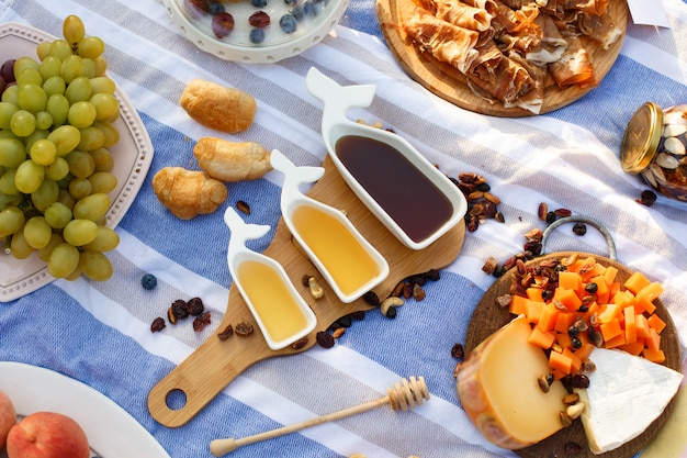 Satz von drei weißen Sauciere mit süßem Honig auf Holztablett am Picknick Essen legen