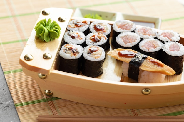 Satz von Maki-Sushi auf hölzernem Bootsfach nahe oben