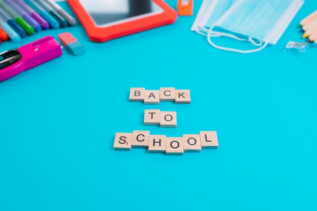 Foto satz von schulgegenständen mit buchstaben auf blauem hintergrund rückkehr zur schule konzept