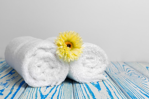saubere weiche Handtücher mit Blume auf Holztisch