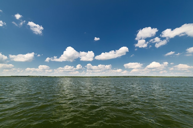 Sauberer See und schöner blauer Himmel mit Wolken