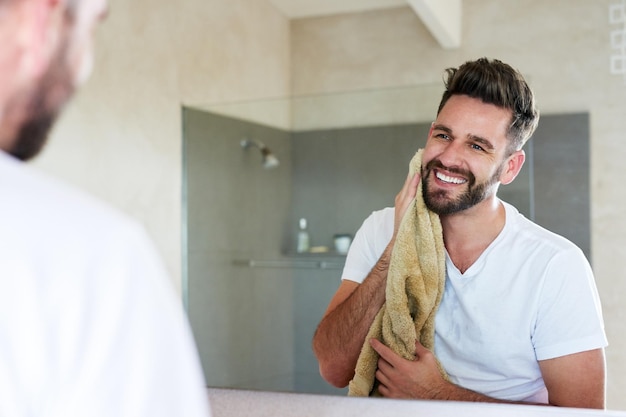 Sauberkeit kommt neben Frömmigkeit Schnittbild eines gutaussehenden jungen Mannes, der die morgendliche Routine im Badezimmer durchläuft