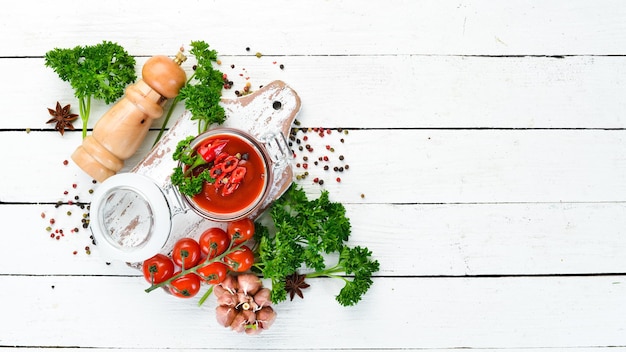 Sauce aus frischen tomaten und chilischoten. tomaten, chilischoten, gewürze und kräuter. ansicht von oben. freiraum für ihren text.