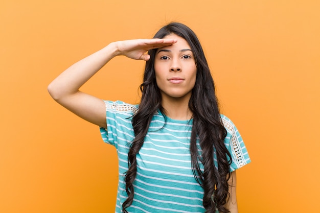 Saudação bonita jovem mulher hispânica com uma saudação militar