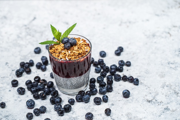 Saudável café da manhã ou lanche da manhã com pudim de sementes de chia, granola, muesli e mirtilos