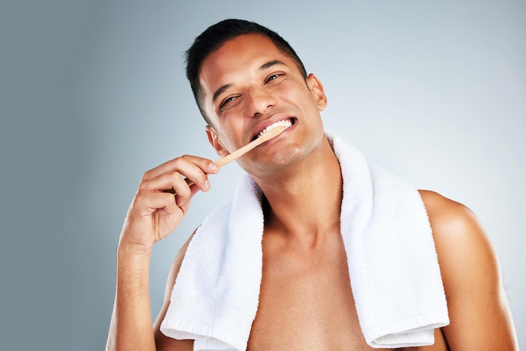Foto saúde bucal e homem usam escova de dentes e creme dental para limpar os dentes para gengivas saudáveis e felizes homem confiante e relaxado mostra higiene bucal com um grande sorriso limpando e escovando os dentes