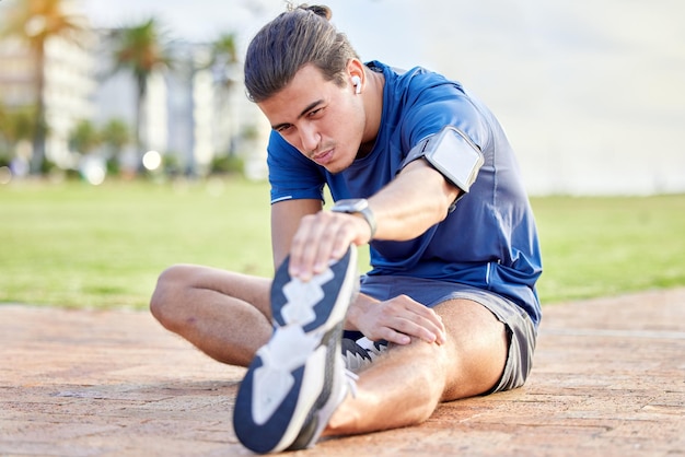 Saúde de fitness de praia ou homem esticando a perna para exercício cardio executando treinamento de maratona ou objetivos de saúde corporal Mentalidade esportiva calma paz ou foco atleta aquecer para treino de desempenho ao ar livre