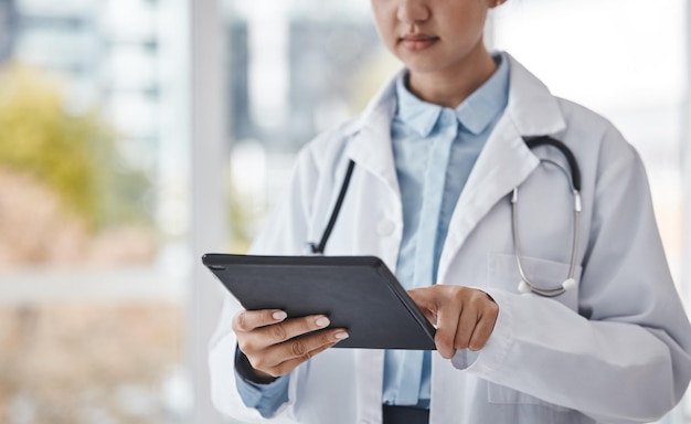 Saúde de tablet digital e médico fazendo pesquisas no hospital para um diagnóstico ou resultados de teste Carreira de tecnologia e close de uma trabalhadora médica em um dispositivo móvel em uma clínica médica