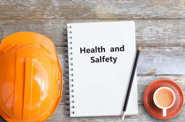 Foto saúde e segurança com lápis de capacete laranja e cadernos