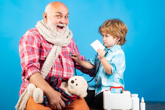 Saúde e seguro de saúde conceito menino médico brincando com pai idoso com pequeno médico fofo ...