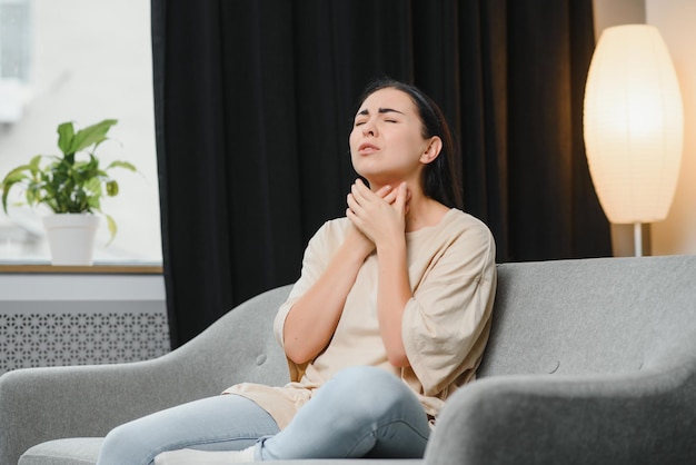 Saúde fria e conceito de pessoas triste jovem asiática doente com dor de garganta em casa