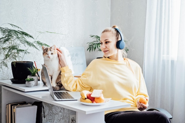 Saúde mental e vida profissional equilibram jovem em fones de ouvido perto de laptop em home office