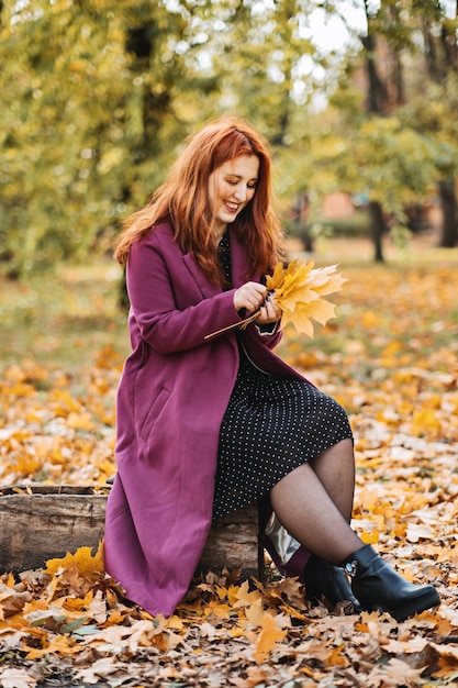 Saúde mental no outono mulher ruiva feliz segurando folhas de outono de bordo amarelo