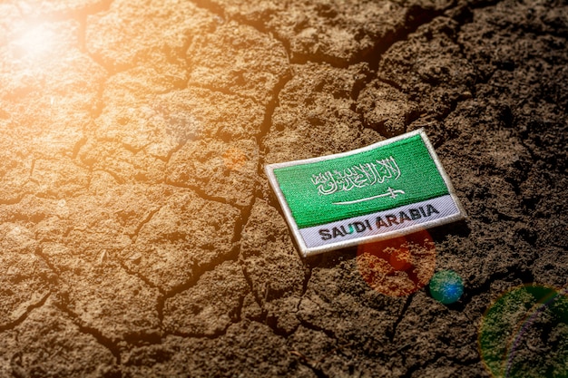 Saudi-Arabien Flagge auf verlassenem rissigem Boden.