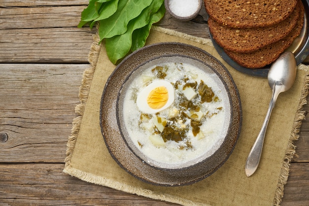 Sauerampfersuppe mit Sahne und Eiern, hölzerne, Draufsicht mit Kopienraum