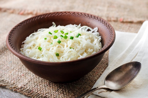 Sauerkraut mit Frühlingszwiebeln in rustikaler Schüssel