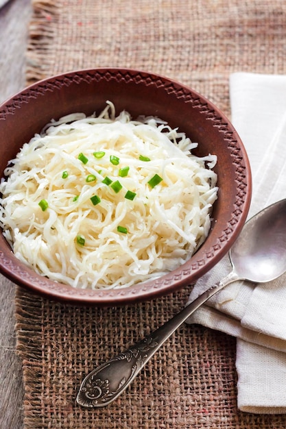 Sauerkraut mit Frühlingszwiebeln in rustikaler Schüssel