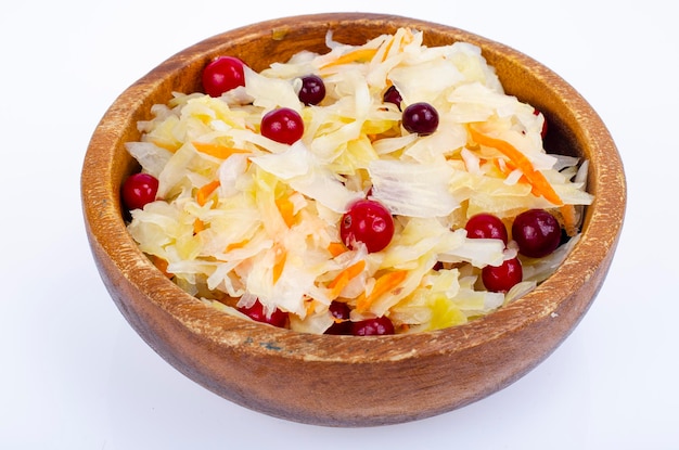 Sauerkraut mit roten Preiselbeeren in Holzschale. Studiofoto