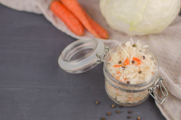 Sauerkraut und Karotten in einem Teller. horizontale Ansicht von oben, rustikaler Stil. Fermentiertes Essen. Speicherplatz kopieren.