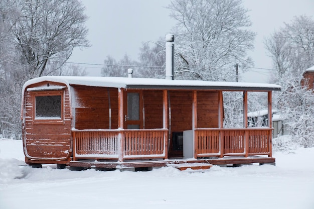 Sauna de madera con terraza en un día de invierno cubierto de nieve para relajarse
