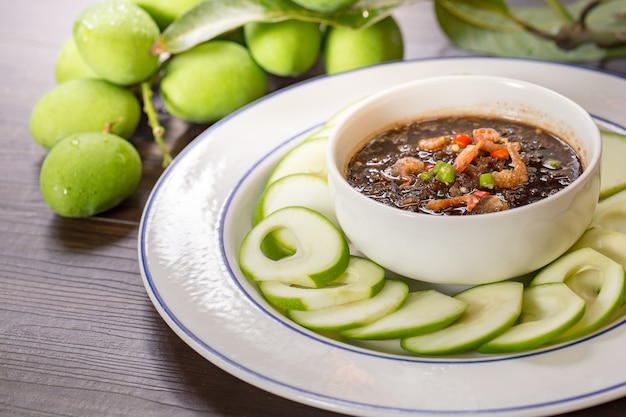 Saure und süße Soße der rohen Mangos mischen Garnelenpaste, thailändischer Snack im weißen Teller