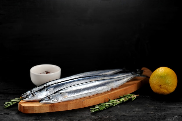 Saury crudo en una tabla de madera