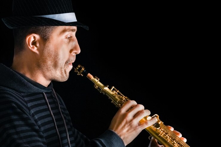 Foto saxofón soprano en las manos de un tipo sobre un fondo negro