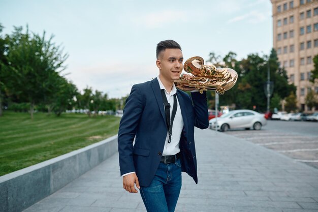 Un saxofonista con saxo, edificios en segundo plano.