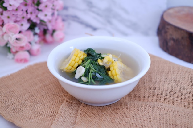 Foto sayur bening daun kelor jagung o sopa clara de moringa oleifera con maíz dulce servida en un cuenco