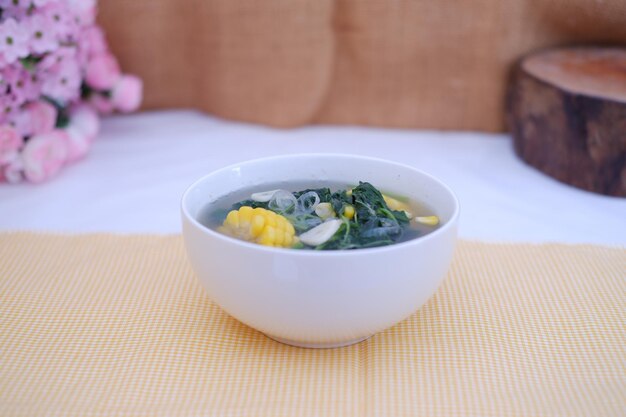 Foto sayur bening daun kelor jagung ou sopa clara de moringa oleifera com milho doce servida em uma tigela