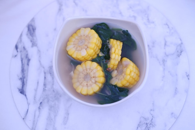 Foto sayur bening daun kelor jagung ou sopa clara de moringa oleifera com milho doce servida em uma tigela